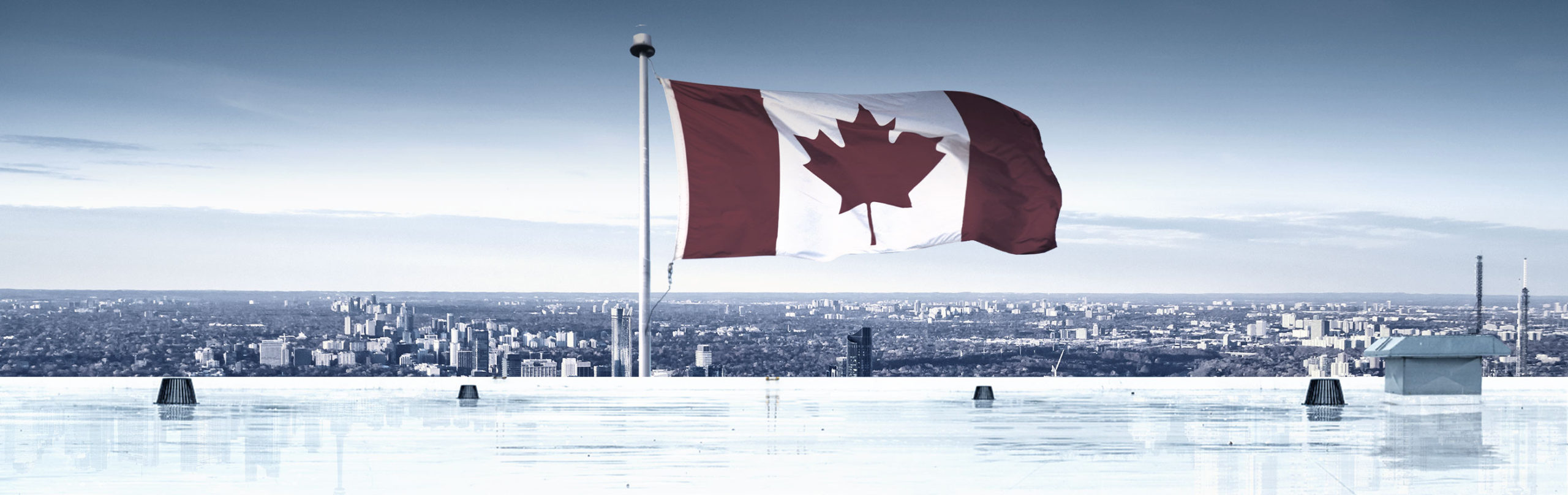 Rooftop view of waving Canada flag with cityscape in background